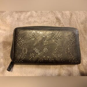 Large black wallet with filigree overlay (gold underneath). Zip closure.